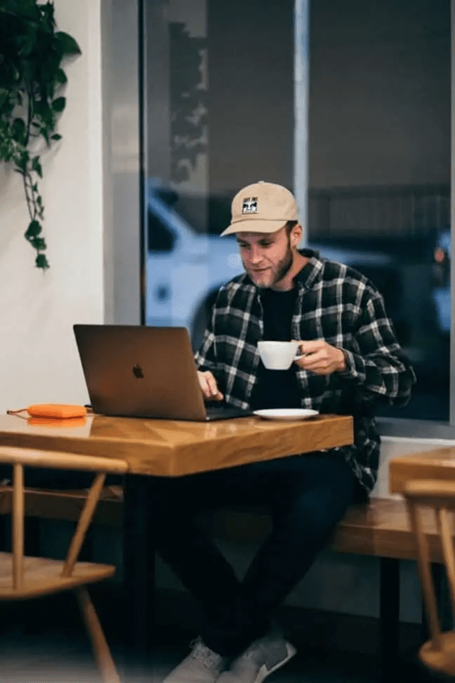man at laptop drinking coffer How to save videos from a closed Facebook group